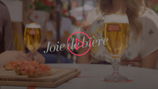 Stella video thumbnail – A pair of Stella beers on a table with a plate of bruschetta